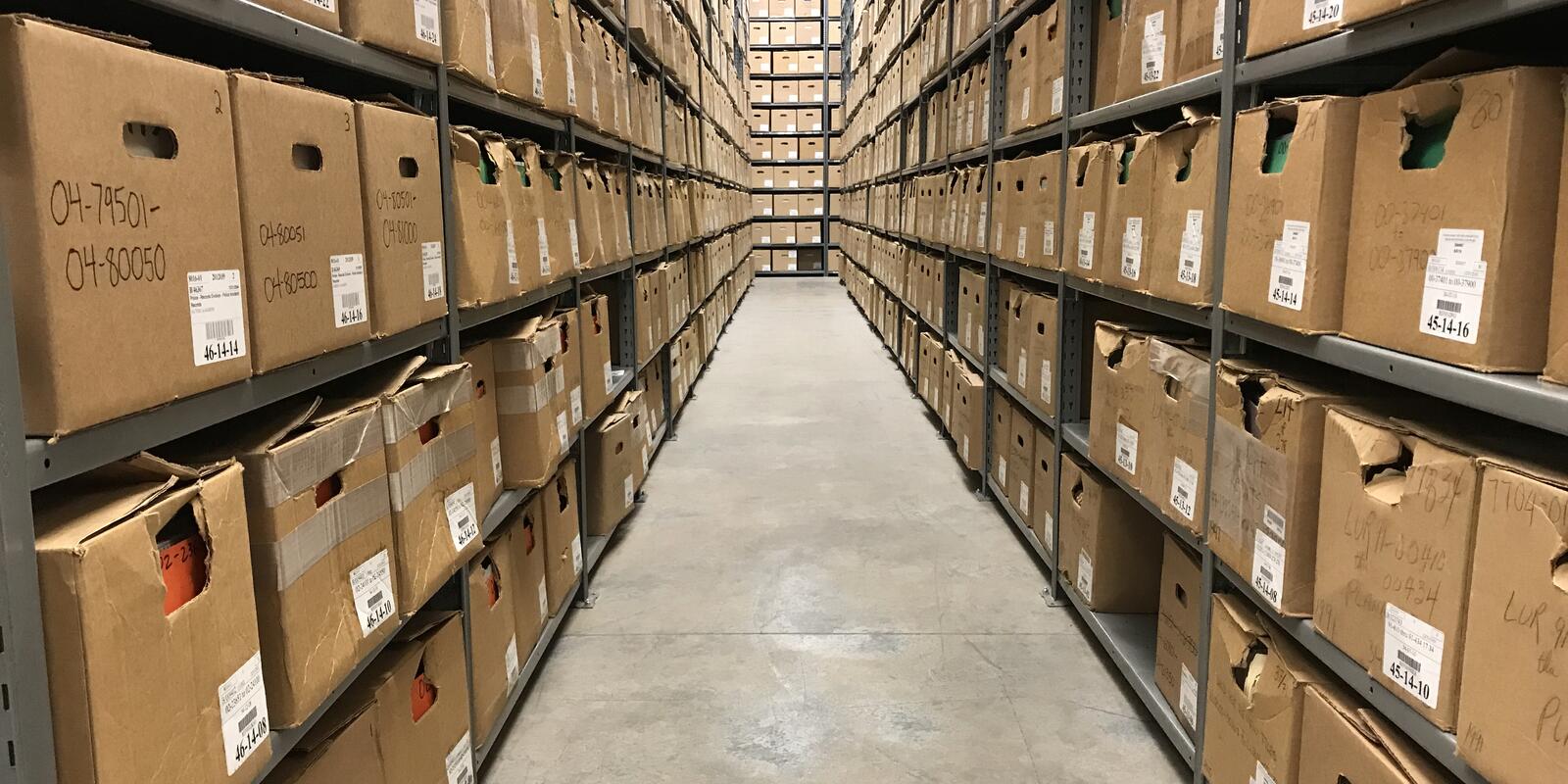 Photo of stacks of archived records on multiple shelving units
